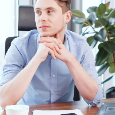 39961807 - to be thoughtful.  young thoughtful businessman in glasses sitting at desk in office have put his arms on desk.